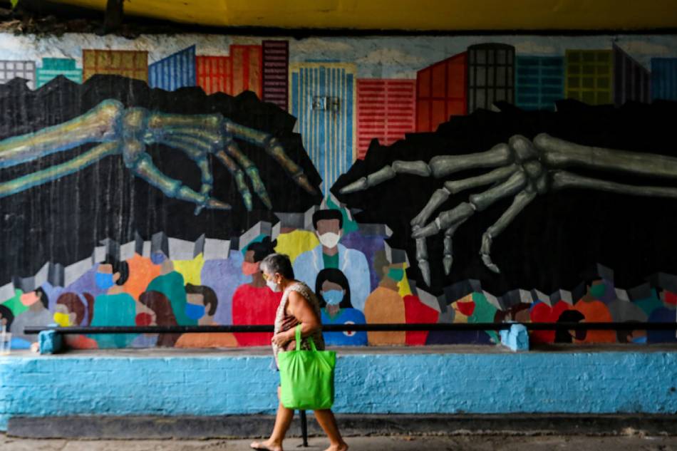A woman walks past a COVID-19 pandemic-themed mural at an underpass in Makati City on July 18, 2022. Jonathan Cellona, ABS-CBN News