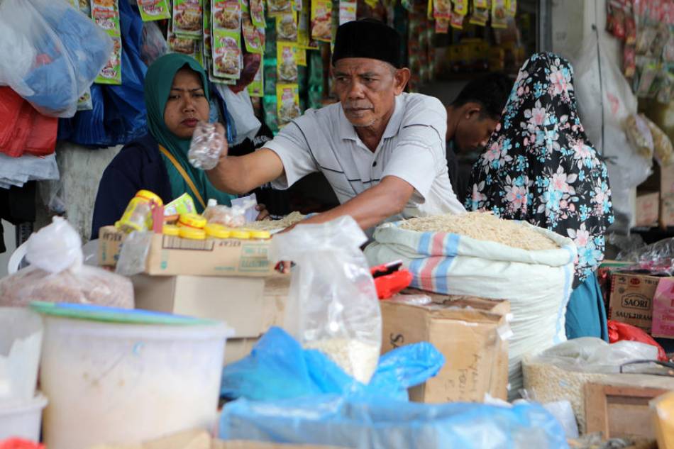 A vendor sorts out food items at a traditional market in Banda Aceh, Indonesia, Aug. 3, 2022. Hotli Simanjuntak, EPA-EFE 