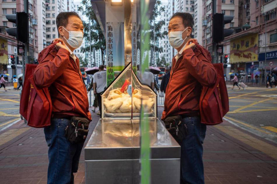 A man wears a face mask to prevent the spread of the COVID-19 coronavirus as he orders from a food shop in Hong Kong, China, March 29, 2022. According to the World Health Organization (WHO) more than 200 symptoms have been observed among long-Covid patients, including fatigue, shortness of breath and cognitive dysfunction. Jerome Favre, EPA-EFE/File 
