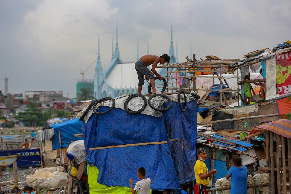 A resident uses plastic sacks and scrap wood as he strengthens a shanty to help make it withstand the storms in Baseco Community in Tondo Manila on June 11, 2021. Jonathan Cellona, ABS-CBN News