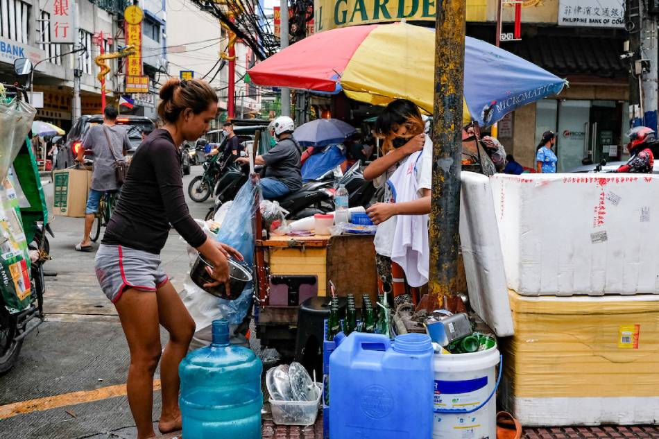  Street vendors wash their pots and pans at a busy intersection in Binondo, Manila on July 21, 2022. George Calvelo, ABS-CBN News/File