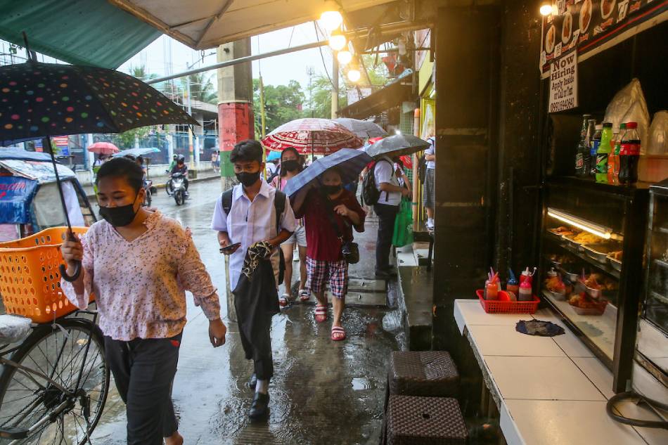 High school students walk along Dagat-dagatan Street in Caloocan City on September 19, 2022 as the monsoon season brings sudden torrential rains in the metro. Jonathan Cellona, ABS-CBN News