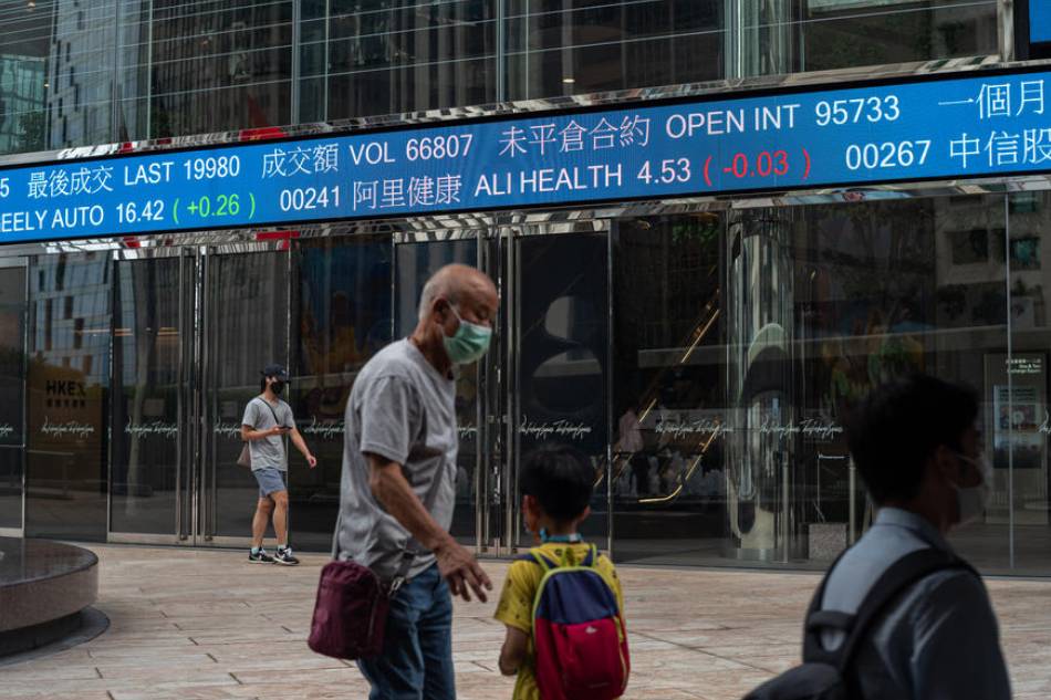 People walk past a stock ticker displaying the Hang Seng Index figure in Hong Kong, China, 29 August 2022. Hong Kong stocks opened lower on 29 August following a drop in Wall Street in response to the US Federal Reserve’s warning of more interest rate hikes. EPA-EFE/JEROME FAVRE