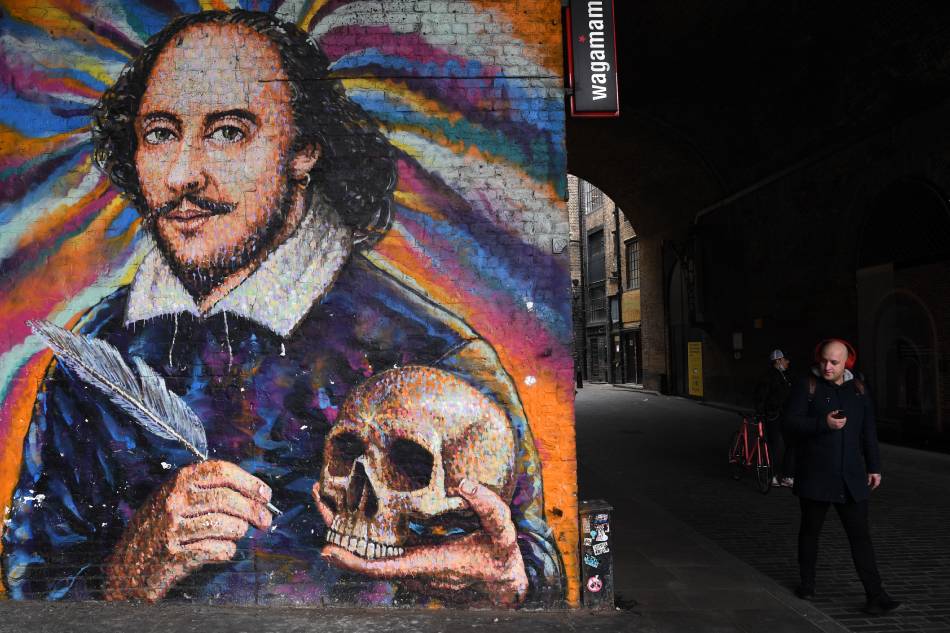 A pedestrian walks past a giant artwork depicting British writer William Shakespeare near London Bridge station in London, Britain, 23 March 2021. A minute of silence was observed across the UK to mark a year since lockdown restrictions over the coronavirus pandemic began. Facundo Arrizabalaga, EPA-EFE.