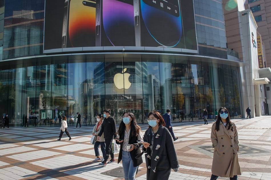 People walk past an Apple store at a mall in Beijing, China, Nov. 3, 2022. Around 600,000 people have been put in lockdown by Chinese authorities near the world's largest iPhone factory in Zhengzhou, Henan province, after COVID-19 cases were recorded on Nov. 2. Mark R. Cristino, EPA-EFE/File 