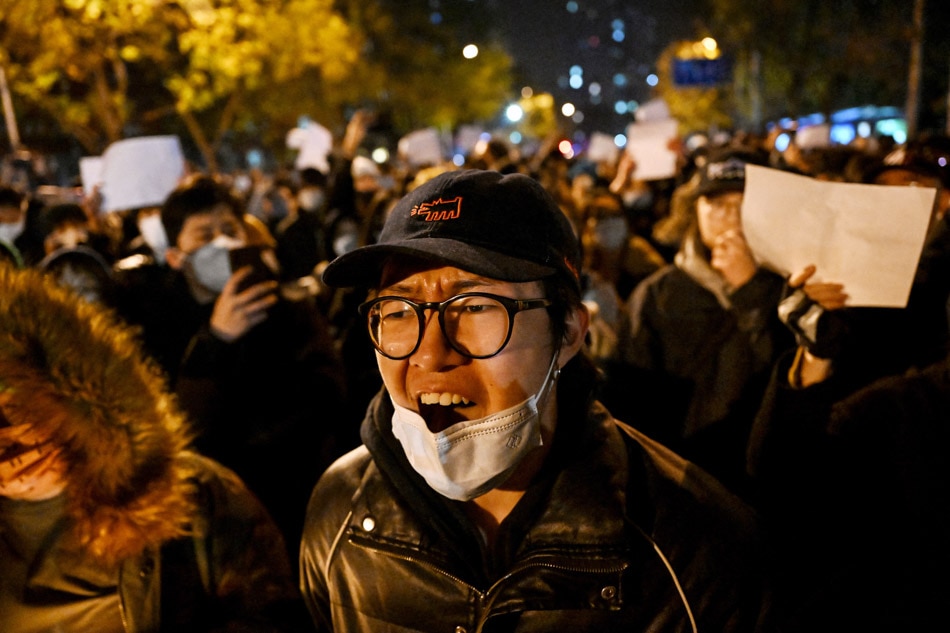 Protesters march along a street during a rally for the victims of a deadly fire as well as a protest against China's harsh COVID-19 restrictions in Beijing on Sunday. Noel Celis, AFP