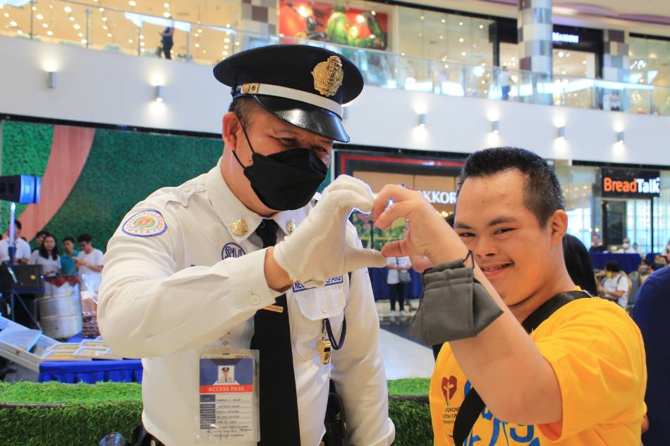 A security guard poses with one of the 'Natatanging Nilalang' kids during the Happy Walk celebration at SM City Bacolod. Photo source: SM Cares
