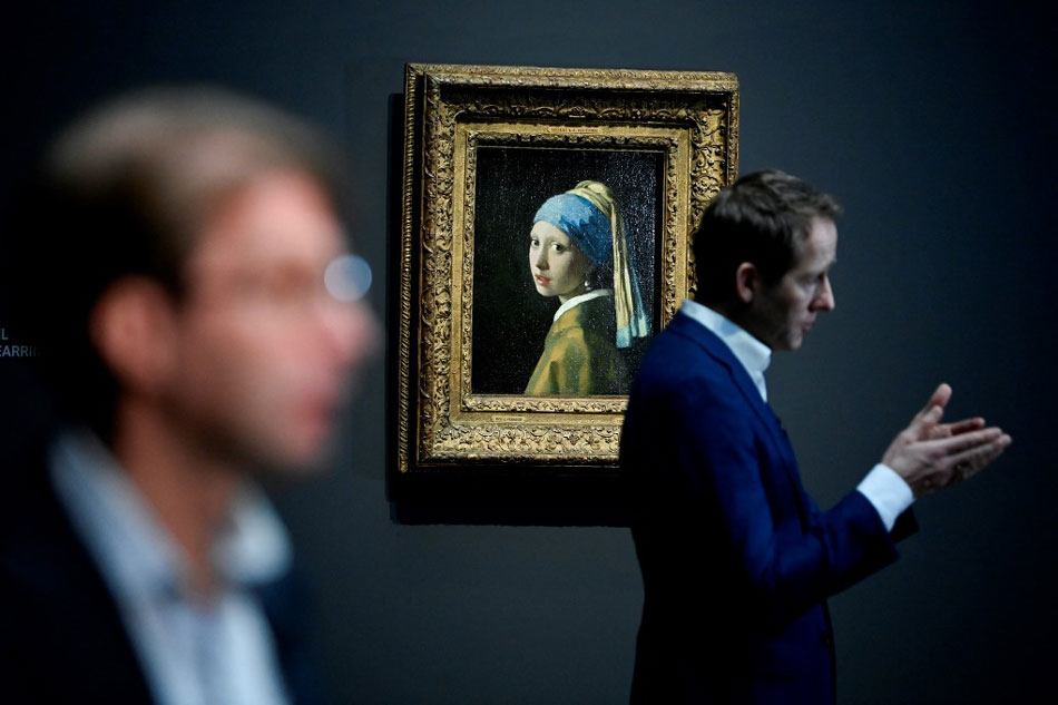 General director of the Rijksmuseum Taco Dibbits speaks to journalists as he stands in front of a painting by the Dutch master Johannes Vermeer titled, 'Girl with a pearl earing' at the Rijksmuseum in Amsterdamk. John Thys, AFP