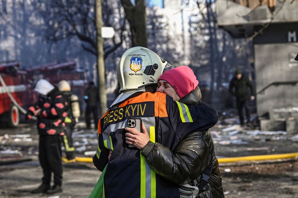 A fireman embraces a woman outside a damaged apartment building in Kyiv on March 15, 2022, after strikes on residential areas killed at least two people, Ukraine emergency services said as Russian troops intensified their attacks on the Ukrainian capital. Aris Messinis, AFP/File 
