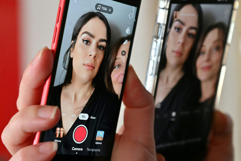  Photo illustration created March 8, 2023 in Washington shows two editors testing the BoldGlamour filter on TikTok. Staff, AFP