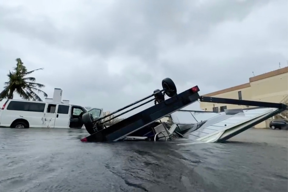  This video capture from James Reynolds' Twitter page @EarthUncutTV shows a vehicle overturned by high winds and precipitation a day after Typhoon Mawar passed over Tumon Bay, Guam, May 25, 2023. Typhoon Mawar passed just north of the US territory of Guam on May 24, the island's governor said, bringing destructive winds to the Pacific military outpost. James Reynolds, AFP