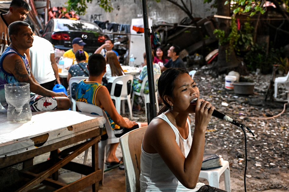 A woman sings a tune from a karaoke machine during a birthday celebration in Manila, Oct. 17, 2023. Karaoke is wildly popular in the archipelago nation where it
