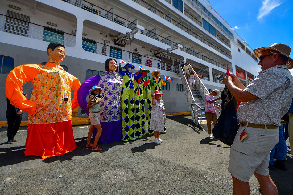 Foreign tourists from the Silver Spirit cruise ship are given a Philippine Fiesta-themed welcome as they arrive at the Eva Macapagal Super Terminal in Manila on Feb. 15, 2023. The event marks the restart of cruise tourism in the country after a three-year hiatus due to the COVID-19 pandemic, according to the Department of Tourism. Mark Demayo, ABS-CBN News
