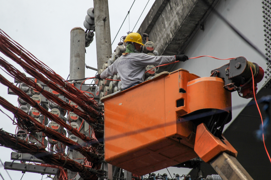 A man lines up an electrical cable on overhead electric meters along Recto Avenue in Manila on July 31, 2019. Jonathan Cellona, ABS-CBN News/File