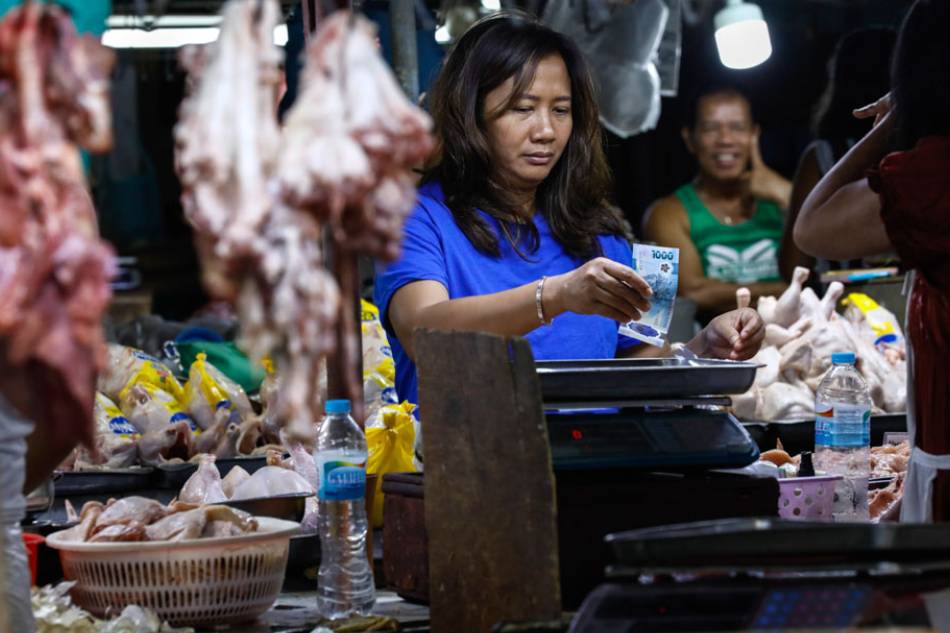 A customer pays for an order of chicken at a market in Quezon City on March 20, 2023. Rolex Dela Pena, EPA-EFE