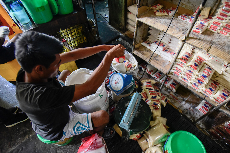 A worker repacks sugar at a store in Visayas Avenue Wet And Dry Public Market in Quezon City on Feb. 16, 2023. Maria Tan, ABS-CBN News/File