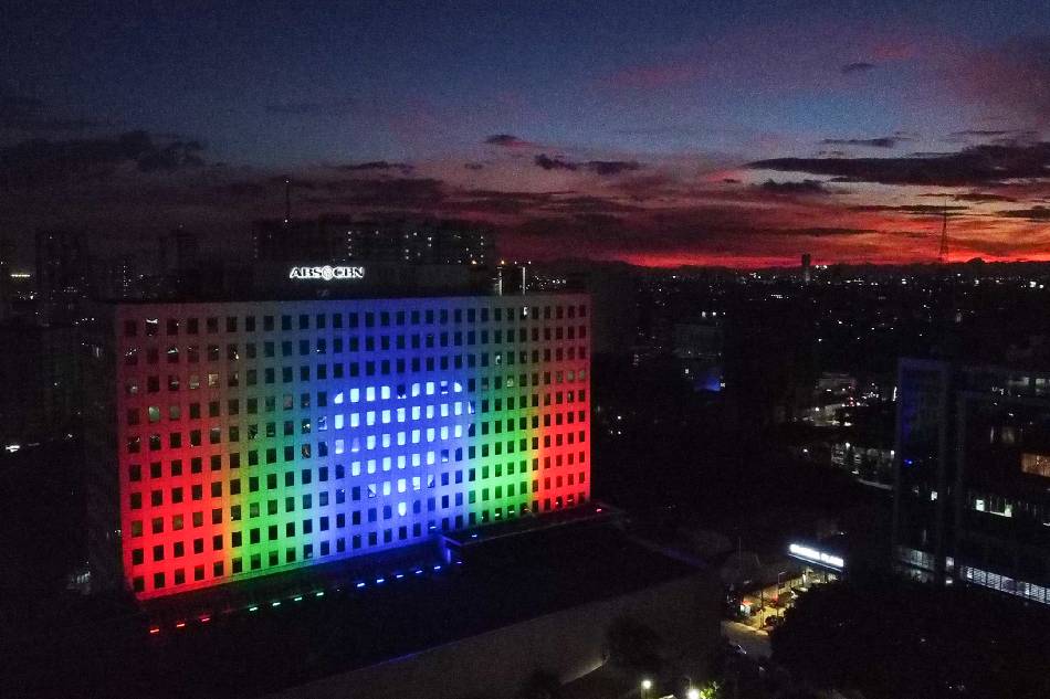 The ABS-CBN ELJ building in Quezon City lights up in the network’s colors on the eve of the first year anniversary of the denial of its franchise renewal at the hands of the House of Representatives on July 9, 2021. Basilio H. Sepe, ABS-CBN News/FILE