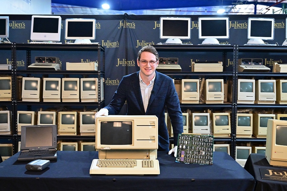 Erik Rosenblum, NFT Development Strategist at Julien's Auctions, poses behind the Apple Lisa, one of the first personal computers released in 1983 on display with motherboard at Julien's Auctions on February 22, 2023 in Gardena, California ahead of 'The Apples' auction scheduled for March 10, 2023 at Julien's Auctions in Beverly Hills. A collection of nearly half a century of computers that trace the evolution of one of the world's most influential companies is going under the hammer in California next month. Frederic J. BROWN / AFP