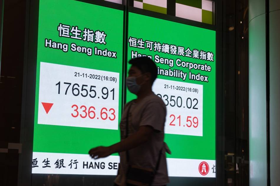 A man walks past an electronic billboard showing the Hang Seng Index closing figure in Hong Kong, China, 21 November 2022. The index dropped 1.9 at the end of trading day, the biggest setback in two weeks. EPA-EFE/JEROME FAVRE