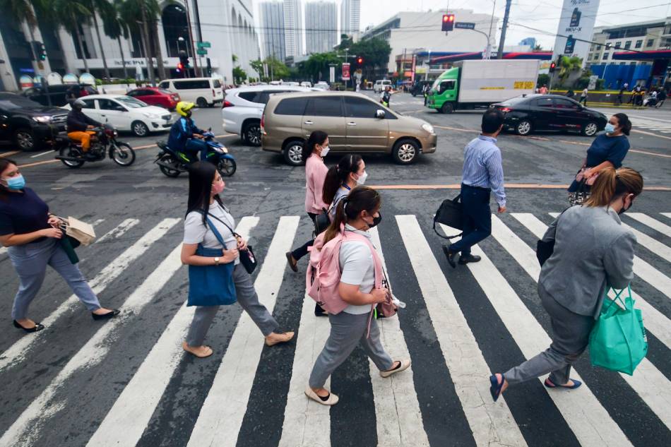 Pedestrians walk at a crossing in Makati City on July 12, 2022. Mark Demayo, ABS-CBN News/FILE