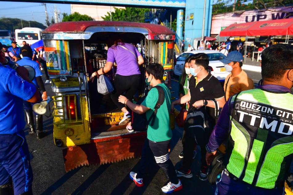 Commuters try to catch a ride along Commonwealth Avenue in Quezon City on March 6, 2023, amid a week-long transport strike by a number of jeepney operators and drivers. Free rides were deployed by local government units and other government agencies to aid commuters amid the strike. Mark Demayo, ABS-CBN News