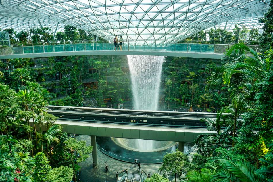 A couple stands on a bridge next to the Rain Vortex in Changi Jewel in Singapore on November 18, 2021. Roslan Rahman, AFP/FILE
