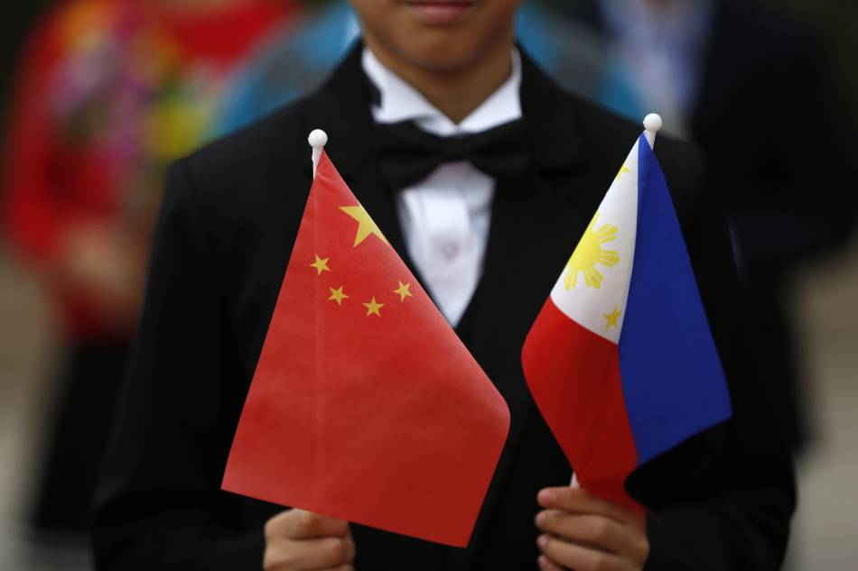 A Chinese boy holds the Chinese and Philippines national flags at the Great Hall of the People in Beijing, China, Oct. 20, 2016. How Hwee Young, EPA/File