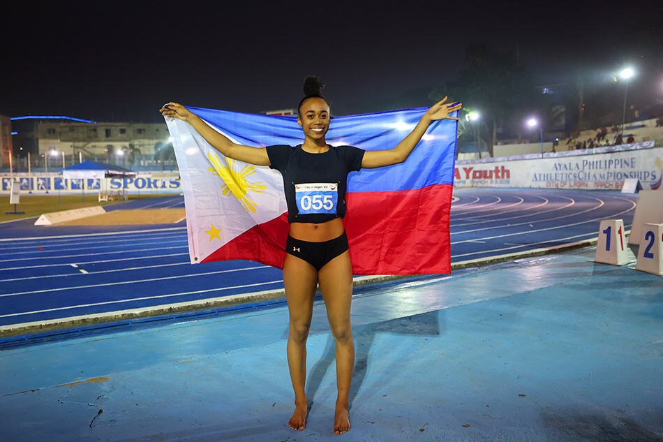 Angel Frank drapes the Philippine flag on herself after clinching the gold medal in the women's 400-meter run. 