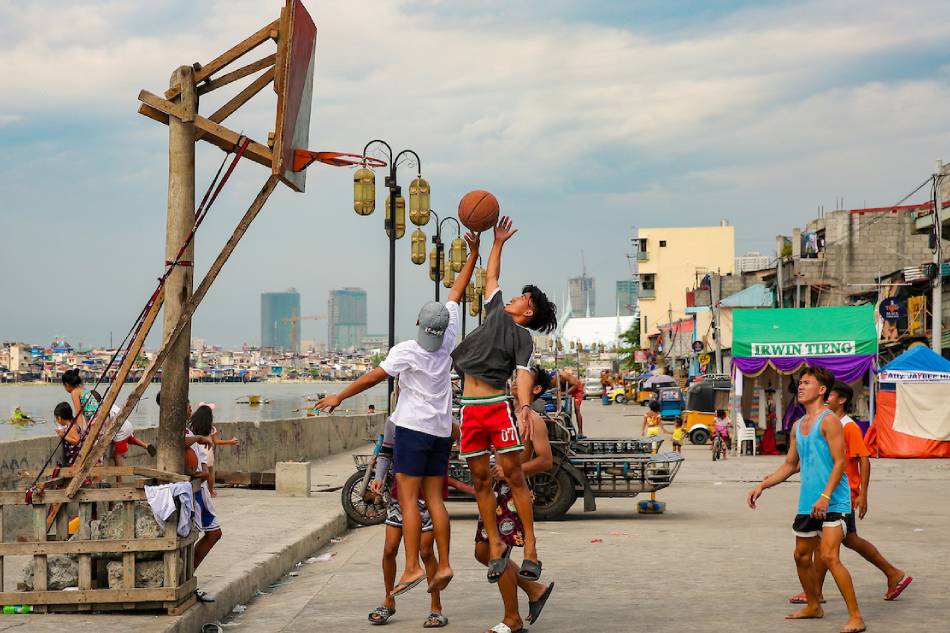 Residents play basketball under the heat of the sun near the Pasig River in Baseco Compound, Tondo, Manila on March 16, 2022. George Calvelo, ABS-CBN News/File