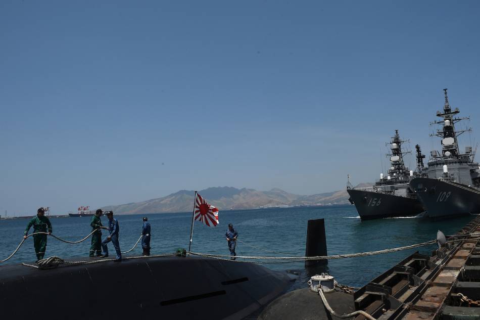 Crew members of Japanese submarine Oyashio (left) work on the deck while Japanese destroyers JS Ariake (109) and JS Setogiri (156) dock at a port of the former US naval base in Subic, Olongapo. Ted Aljibe, ABS-CBN News/file