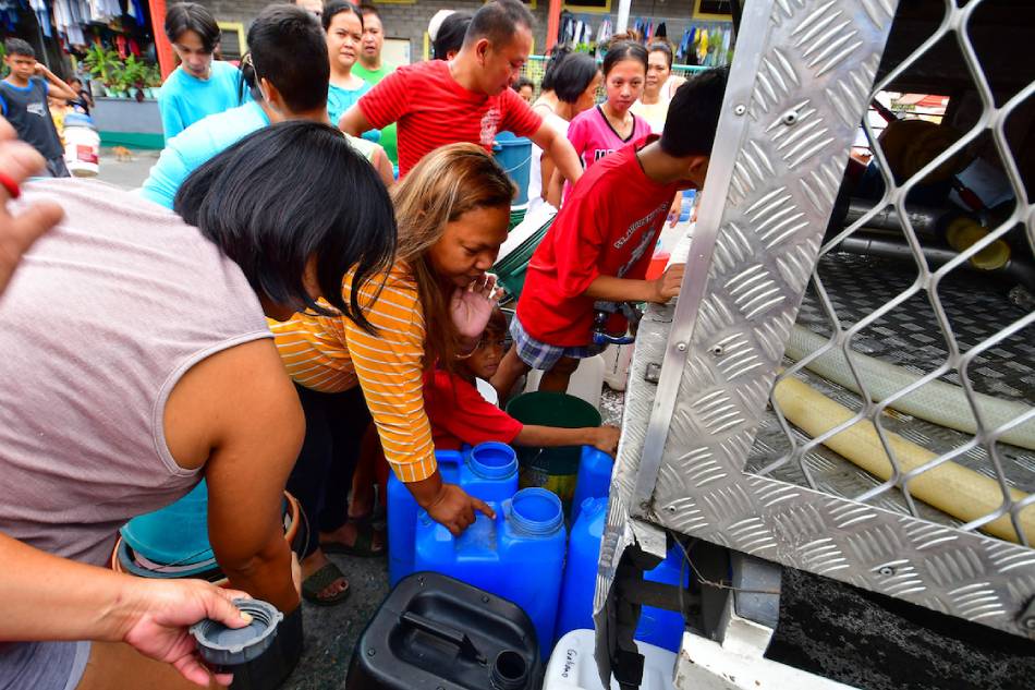 Residents of Barangay 165 in Pasay City stock up on delivered water from a mobile tanker on March 5, 2023. Mark Demayo, ABS-CBN NEWS