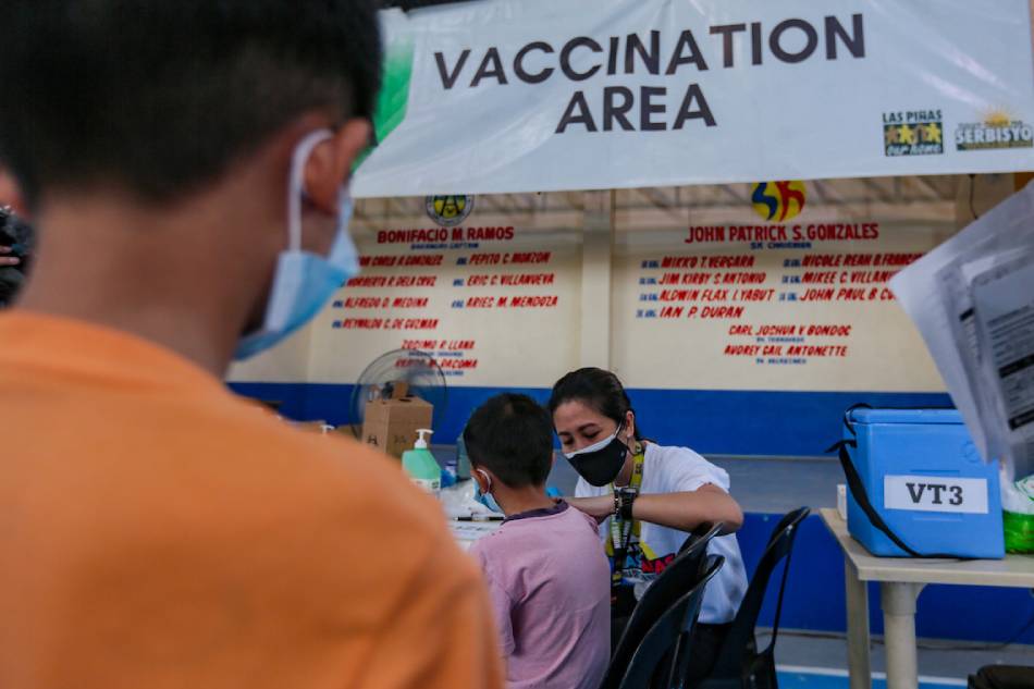 Parents and guardians accompany their children to get vaccinated at the Almanza Uno covered court in Las Piñas City on Dec. 7, 2022. George Calvelo, ABS-CBN News/File