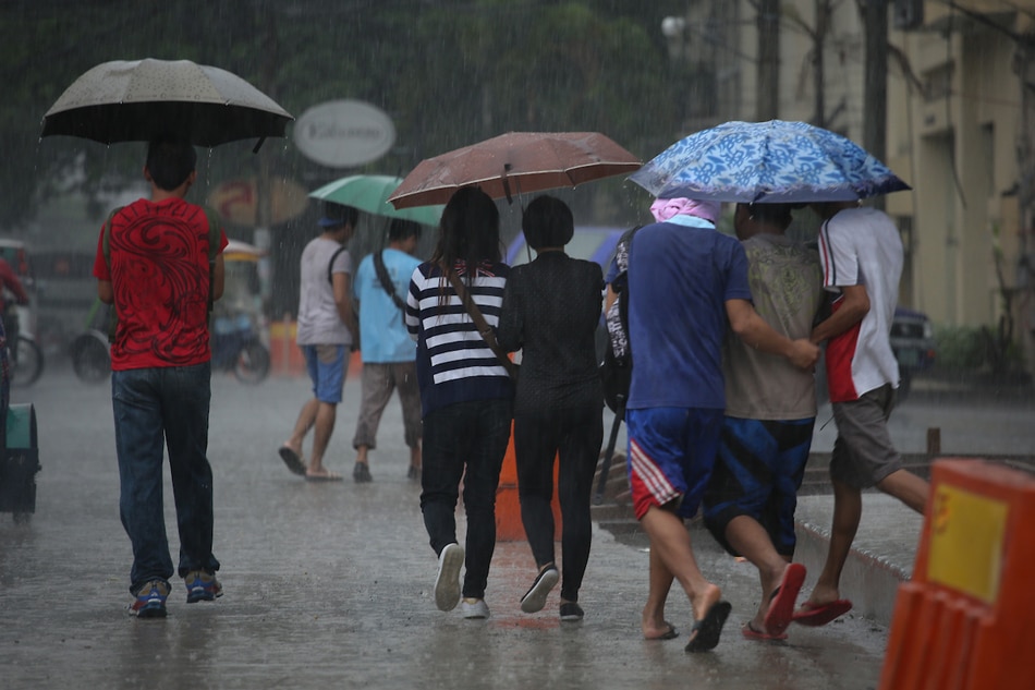 Workers share umbrellas as they walk to work on Friday amid heavy rainfall. 📷: Fernando G. Sepe Jr., ABS-CBN News/file