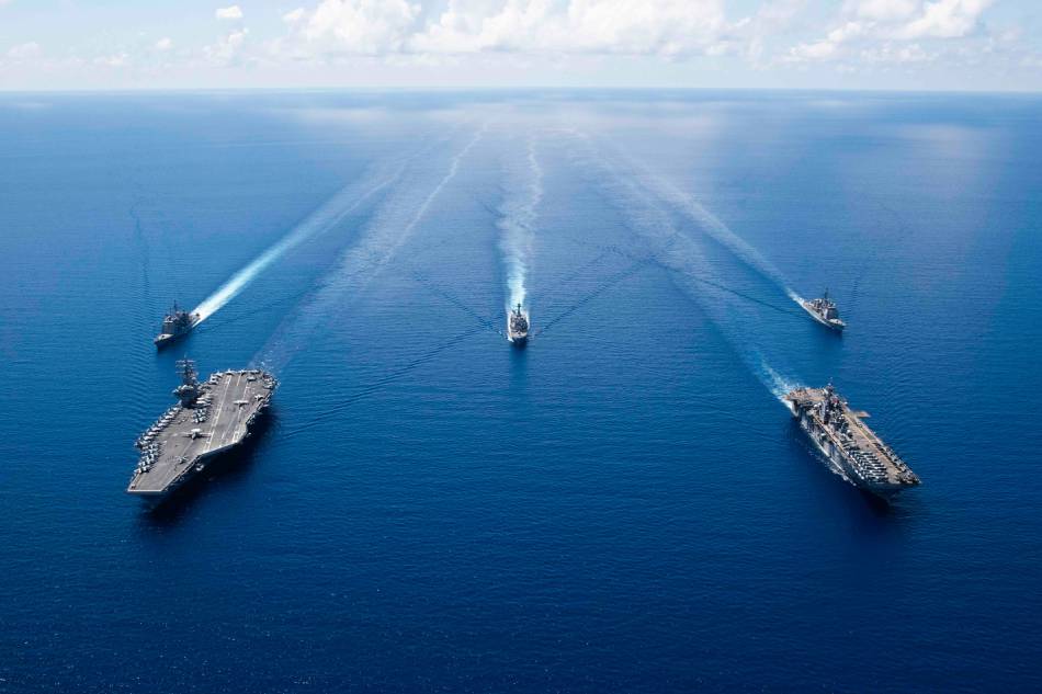 This US Navy photo obtained Oct. 7, 2019 shows the aircraft carrier USS Ronald Reagan (CVN 76)(L), and the amphibious assault ship USS Boxer (LHD 6) and ships from the Ronald Reagan Carrier Strike Group and the Boxer Amphibious Ready Group underway in formation while conducting security and stability operations in the US 7th Fleet area of operations on Oct. 6, 2019 in the South China Sea. US 7th Fleet is the largest numbered fleet in the world, and the US Navy has operated in the Indo-Pacific region for more than 70 years, providing credible, ready forces to help preserve peace and prevent conflict. Erwin Jacob V. Miciano, Navy Office of Information via AFP