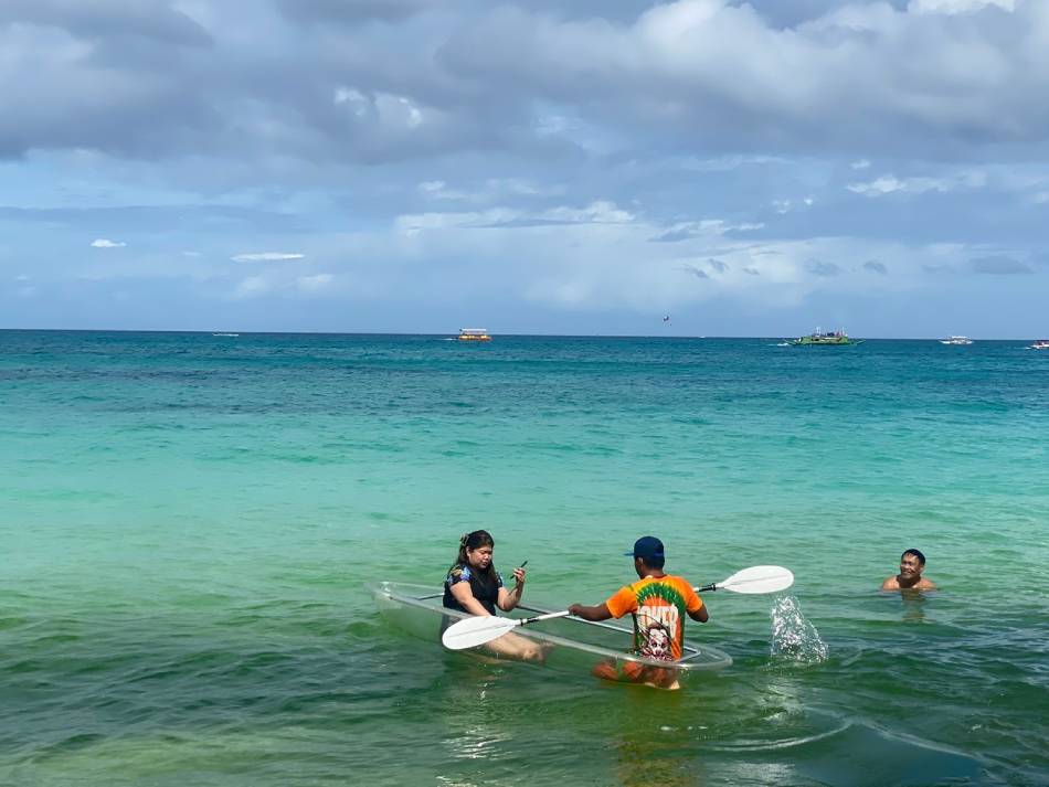 Vince Abresado assisting a tourist in his rented-kayak. Jessica Fenol, ABS-CBN News