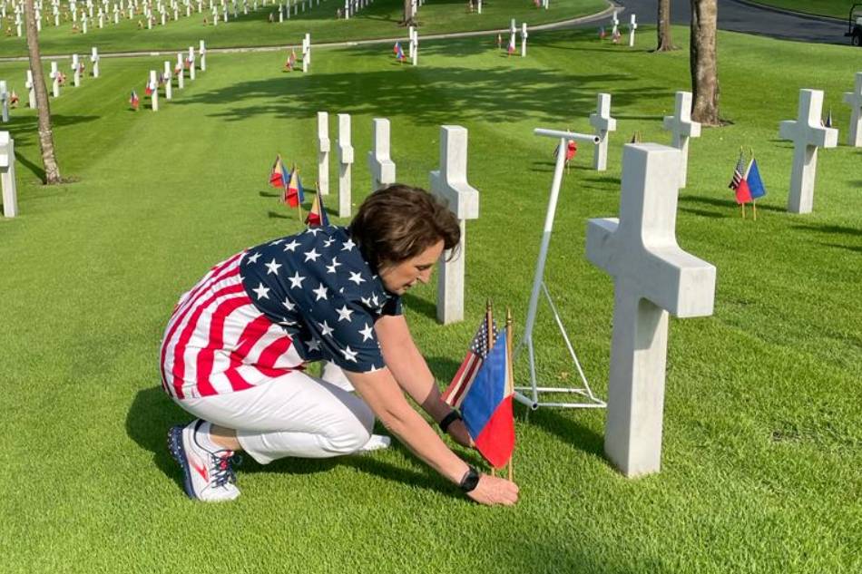 United States Ambassador MaryKay Carlson places US and Philippine flags at the graves of fallen American and Filipino soldiers on May 27, 2023, ahead of this year's Memorial Day rites. Courtesy: US Embassy in the Philippines/Facebook