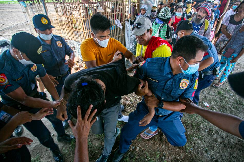 Members of the Philippine National Police in Concepcion, Tarlac arrest some 87 people on June 9, 2022 after a group of activists, cultural workers, and local farmers cultivated a piece of disputed land in Tinang village. The farmers, who are Comprehensive Agrarian Reform Program beneficiaries, say they have been tilling the land for the past 27 years and are waiting for their official installation this month as previously promised by Department of Agrarian Reform Undersecretary John Lana. Mark Saludes, ABS-CBN News