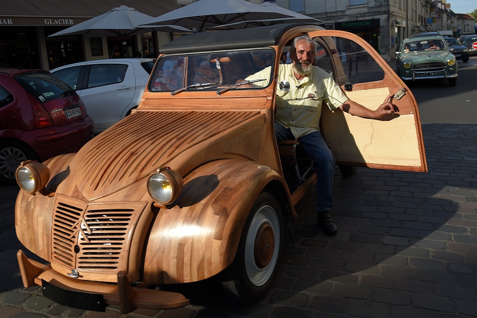 French cabinetmaker Michel Robillard poses in his wooden 2CV Citroen car in the streets of Loches, France in this September 23, 2017 file photo. Guillaume Souvant, AFP