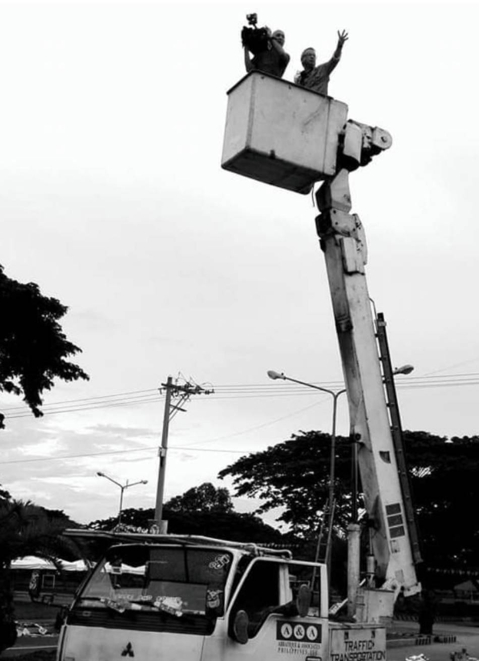 Mario Dumaual and long-time cameraman Ricky Bautista ride atop a Meralco cherry-picker truck to get a good vantage point for a shot and standupper. Courtesy: Ricky Bautista