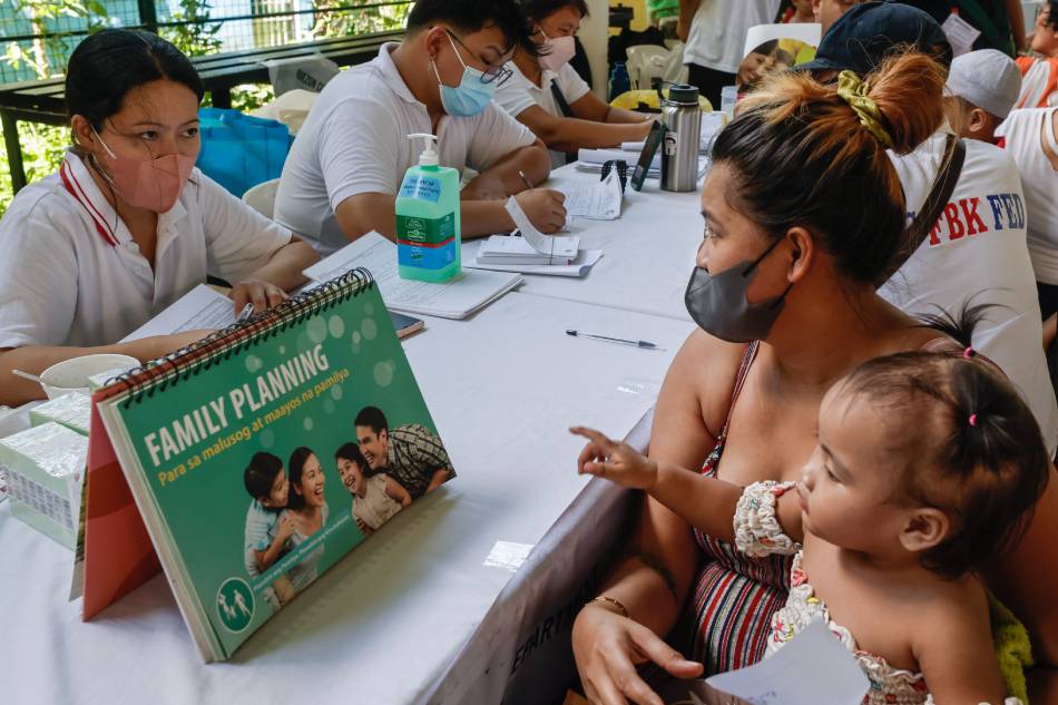A mother (R) receives a free consultation with a family planning nurse (L) during a social services caravan organized by local district officials in Quezon City on July 11, 2023. The United Nations marks World Population Day annually on July 11, with this year