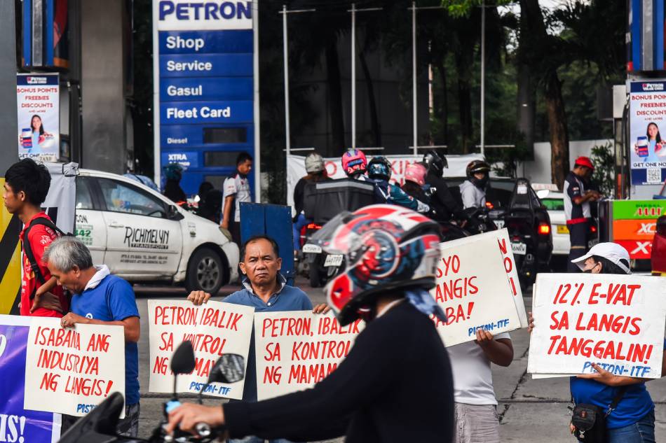 Members of transport group PISTON hold a protest against consecutive oil price hikes in front of a gas station in East Avenue, Quezon City on August 15, 2023. Maria Tan, ABS-CBN News