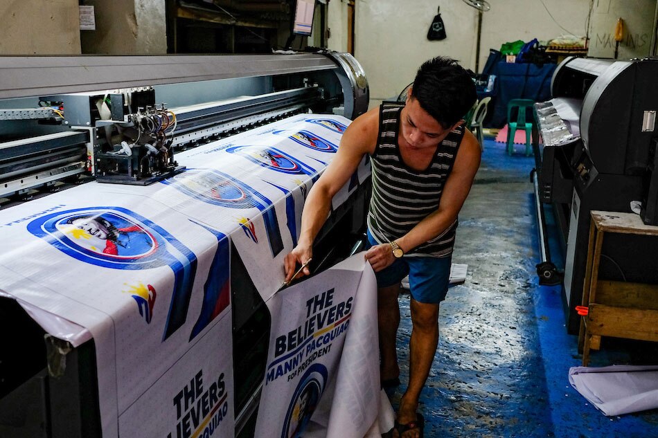  Men work inside a tarpaulin printing shop in Manila on April 19, 2022. George Calvelo, ABS-CBN News/file