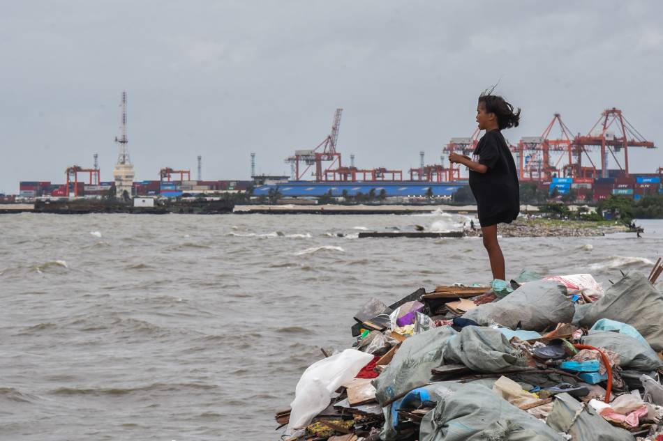 Residents collect garbage as rough waves and strong winds from several weather disturbances continue to affect the country on Sept. 1, 2023. Maria Tan ABS-CBN News 