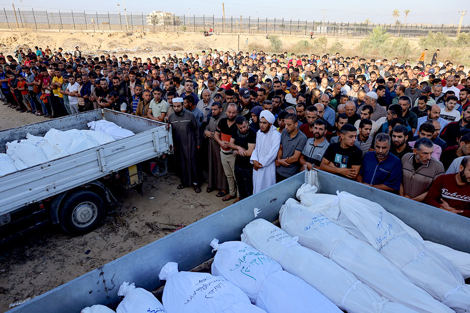Palestinians pray near the bodies of members of the Hijazi family, killed in Israeli strikes in Rafah in the southern Gaza Strip before their burial on November 10, 2023, amid ongoing battles between Israel and the Palestinian group Hamas. Photo by MOHAMMED ABED / AFP