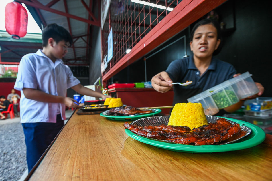 Attendants serving unlimited rice prepare orders at a roadside eatery along Visayas Avenue in Quezon City on November 17, 2023. Maria Tan, ABS-CBN News