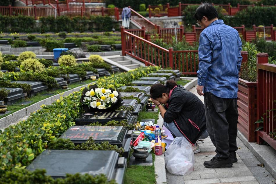 This photo taken on Nov. 7, 2023 shows Seakoo Wu and his wife visiting the grave of their son Wu Xuanmo, who died last year aged 22 while attending Exeter University in Britain, at a cemetery in China