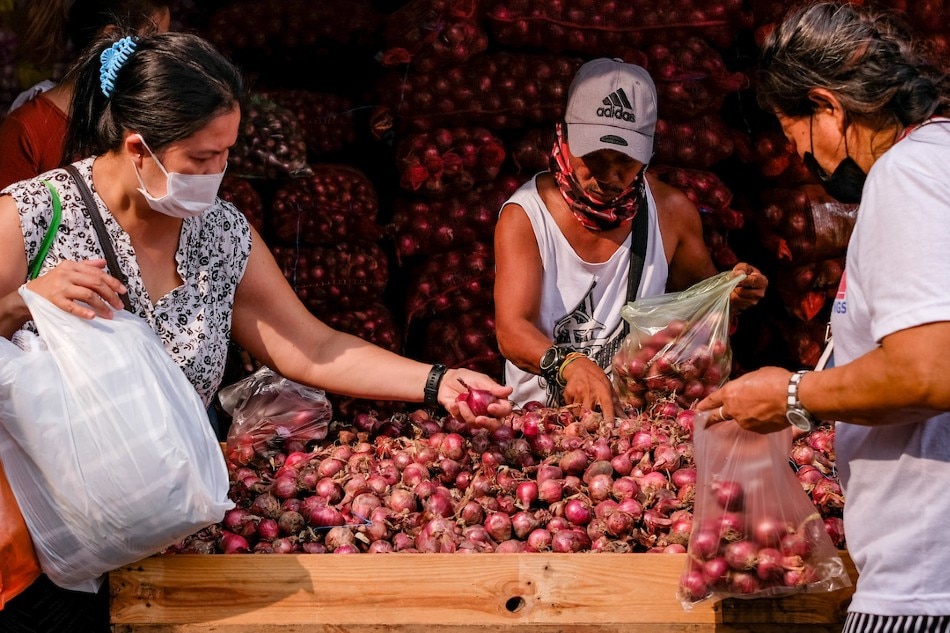 Customers sift through red onions at a stall in Divisoria market in Manila on Aug. 18, 2022. George Calvelo, ABS-CBN News