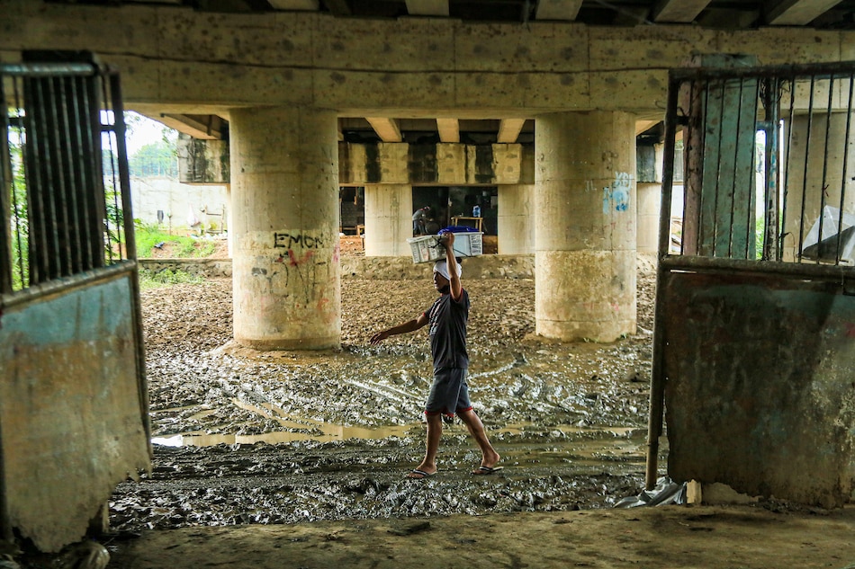 People pass through a muddy area under the San Mateo-Batasan Bridge on Sept. 29, 2022, days after Typhoon Karding inundated parts of Luzon. Jonathan Cellona, ABS-CBN News/File