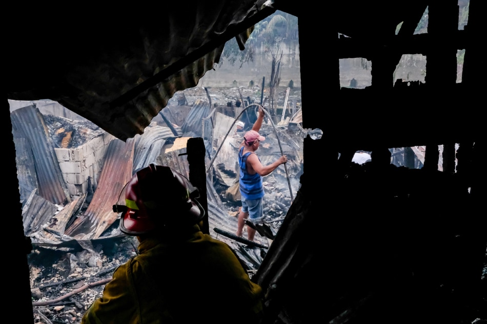 Residents return to look for salvageable materials after a fire in Barangay Roxas in Quezon City on January 28, 2023. George Calvelo, ABS-CBN News