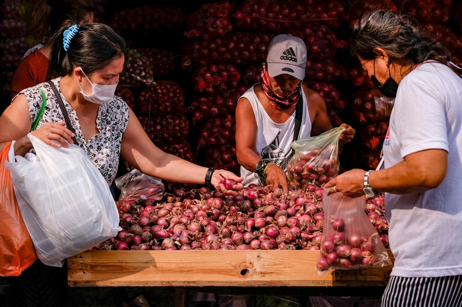 Customers sift through red onions at a stall in Divisoria market in Manila on August 18, 2022. George Calvelo, ABS-CBN News